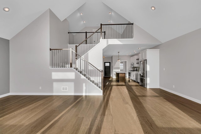 interior space with high vaulted ceiling and dark wood-type flooring