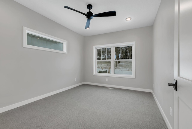 carpeted spare room featuring ceiling fan