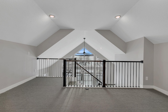 hall featuring carpet and lofted ceiling