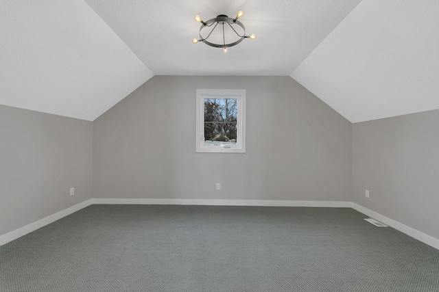 additional living space with carpet, lofted ceiling, and a textured ceiling