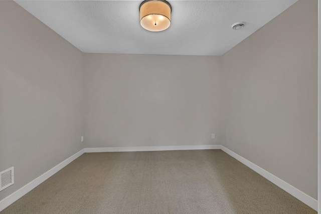 unfurnished room with a textured ceiling and carpet floors