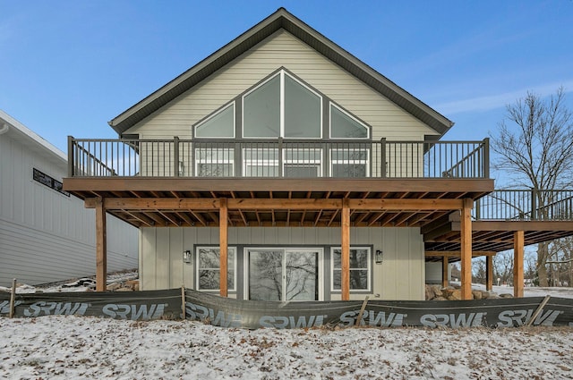 snow covered rear of property with a deck