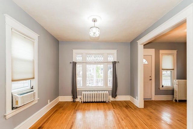 foyer entrance featuring light hardwood / wood-style flooring, radiator, and cooling unit