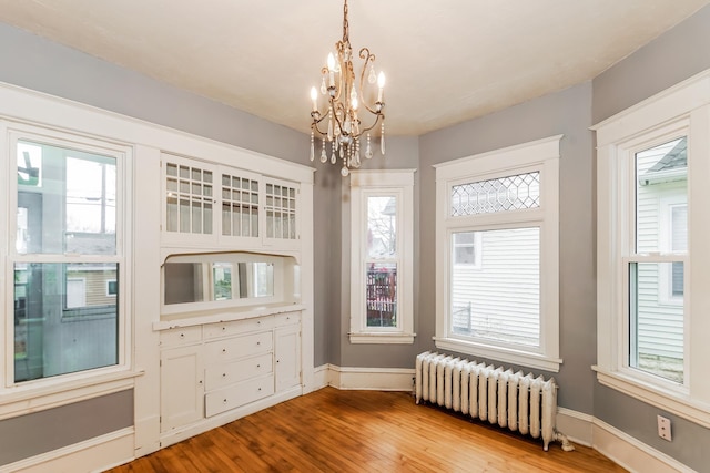 interior space featuring radiator heating unit and an inviting chandelier