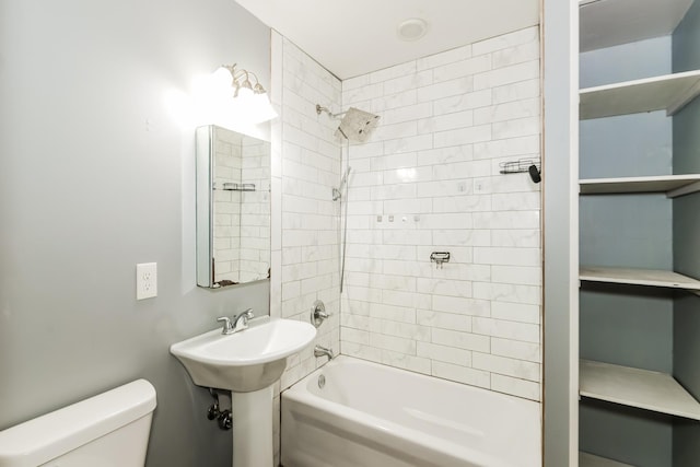 full bathroom with sink, tiled shower / bath, and toilet