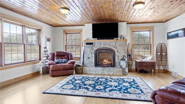 sitting room featuring a tile fireplace, hardwood / wood-style floors, crown molding, and wood ceiling