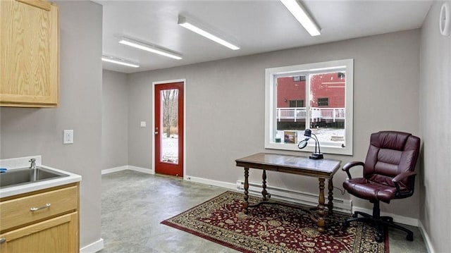 office space featuring sink, concrete flooring, and a baseboard radiator