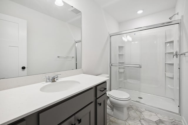 bathroom with vanity, toilet, and a shower with door