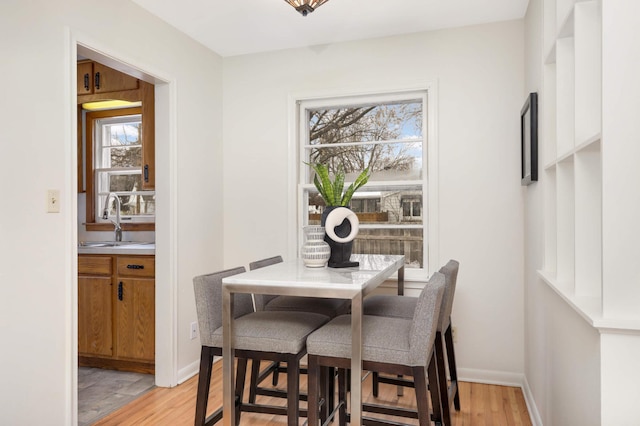 dining space featuring sink and light hardwood / wood-style flooring