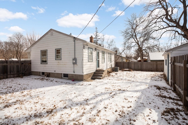 snow covered property with central AC