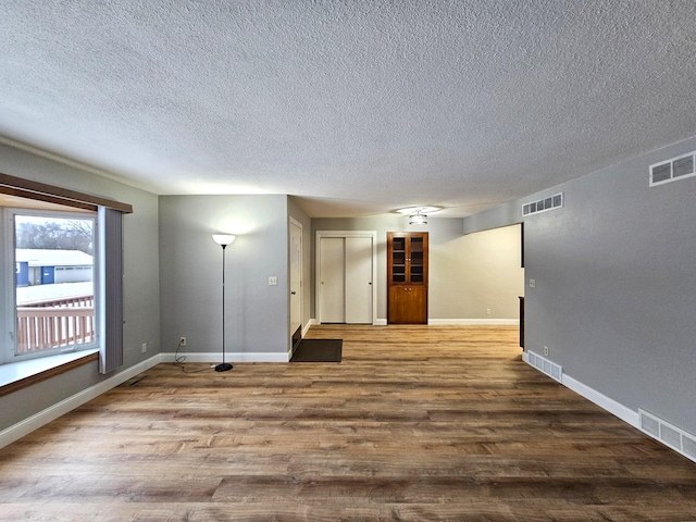 spare room featuring a textured ceiling and hardwood / wood-style flooring