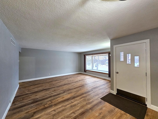 entrance foyer with dark hardwood / wood-style flooring and a textured ceiling