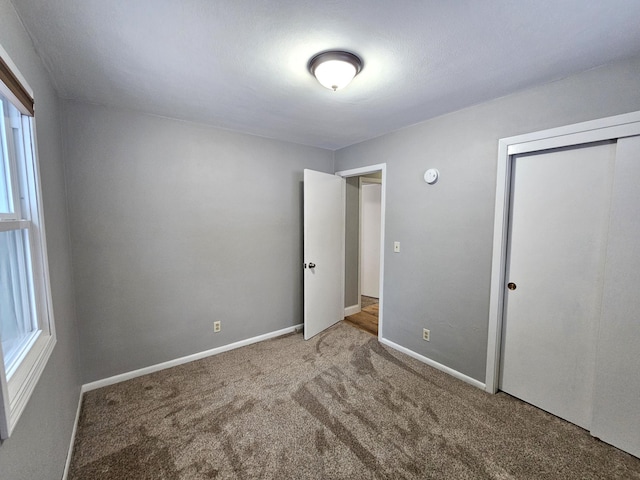 unfurnished bedroom featuring carpet floors and a closet