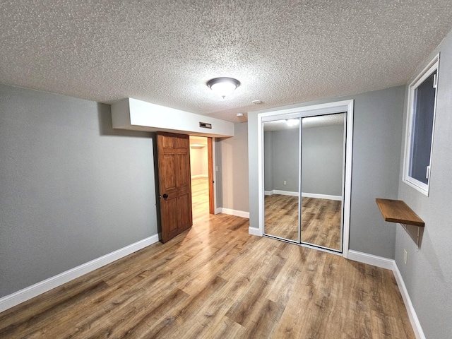 unfurnished bedroom with a closet, light hardwood / wood-style flooring, and a textured ceiling