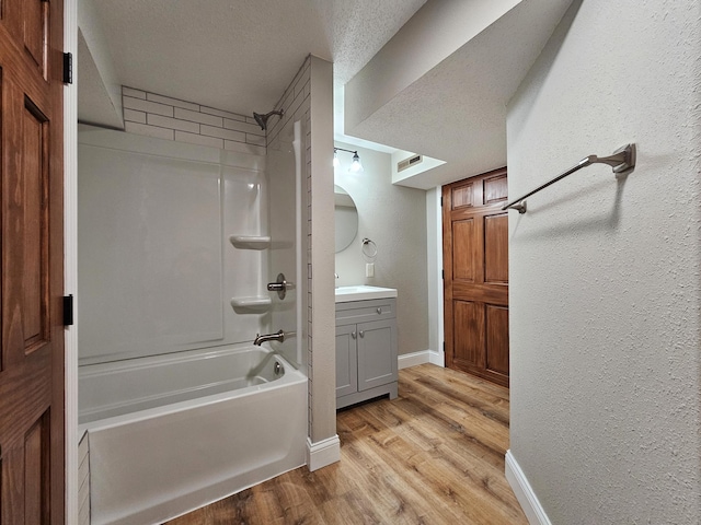 bathroom featuring vanity, hardwood / wood-style floors, a textured ceiling, and shower / bath combination