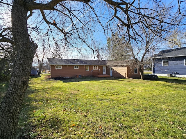 rear view of property featuring a lawn