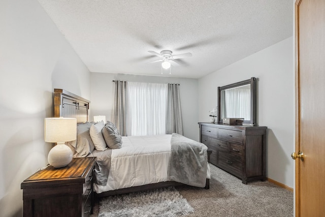 bedroom featuring ceiling fan, light colored carpet, a textured ceiling, and multiple windows