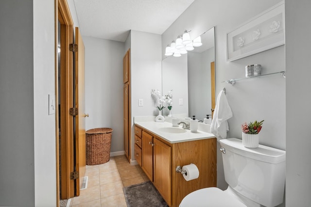 bathroom with tile patterned flooring, vanity, a textured ceiling, and toilet