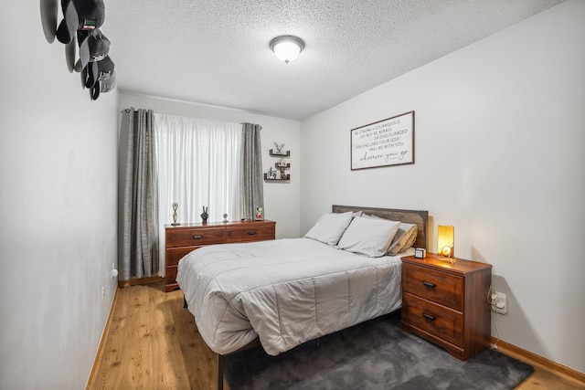 bedroom featuring hardwood / wood-style floors and a textured ceiling