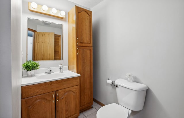 bathroom featuring tile patterned floors, vanity, and toilet