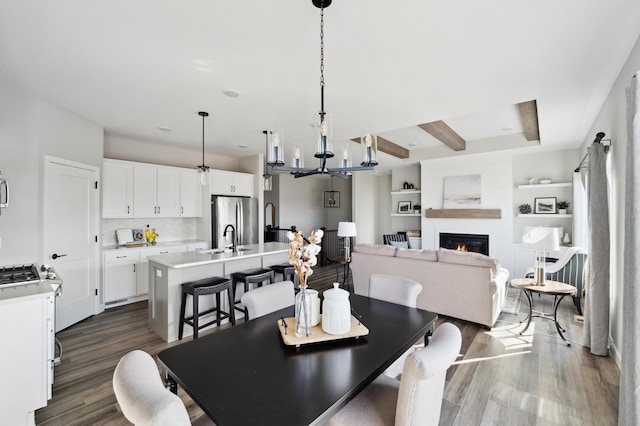 dining room featuring sink, dark wood-type flooring, and a notable chandelier