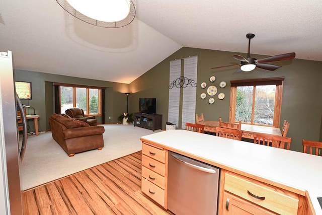 kitchen featuring appliances with stainless steel finishes, light brown cabinetry, light colored carpet, vaulted ceiling, and ceiling fan