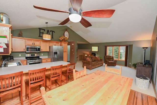 dining room with ceiling fan, sink, and vaulted ceiling