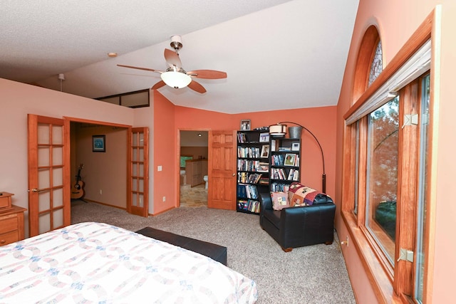 carpeted bedroom with ceiling fan, lofted ceiling, a textured ceiling, and french doors