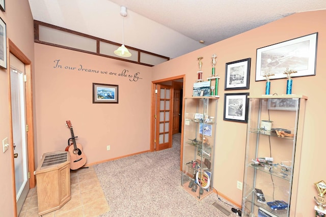 miscellaneous room with light tile patterned floors, a textured ceiling, and vaulted ceiling