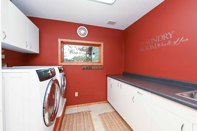 laundry room with sink, cabinets, separate washer and dryer, a textured ceiling, and light tile patterned floors