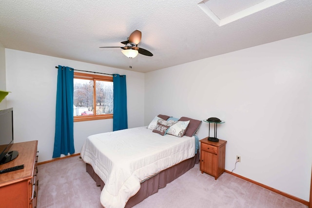 carpeted bedroom featuring ceiling fan and a textured ceiling