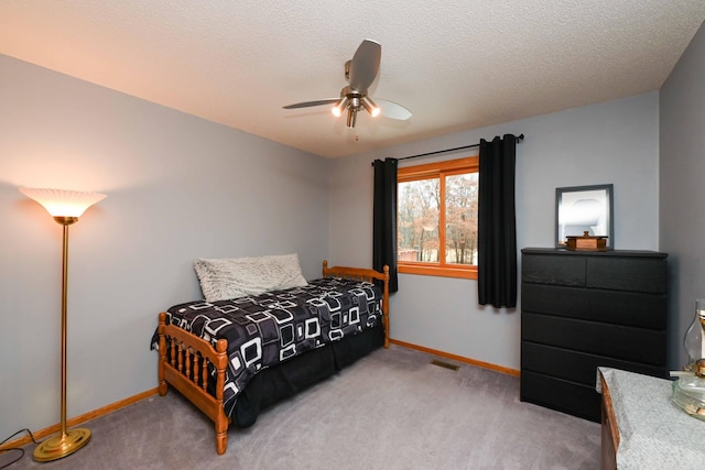 bedroom featuring ceiling fan, carpet floors, and a textured ceiling