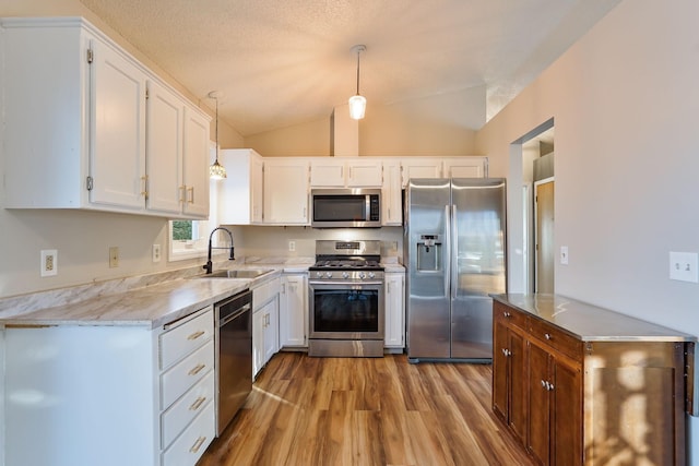 kitchen featuring pendant lighting, white cabinetry, sink, and appliances with stainless steel finishes