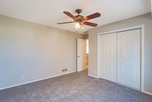 unfurnished bedroom featuring ceiling fan, carpet floors, a textured ceiling, and a closet