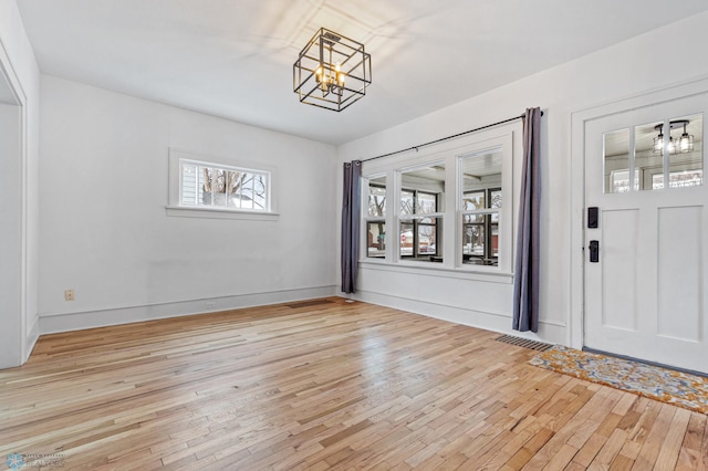 entrance foyer with a notable chandelier and light hardwood / wood-style flooring