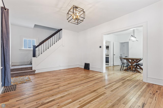 1018 11th St S, Fargo, ND 58103 - unfurnished living room featuring light wood finished floors, stairs, and a chandelier