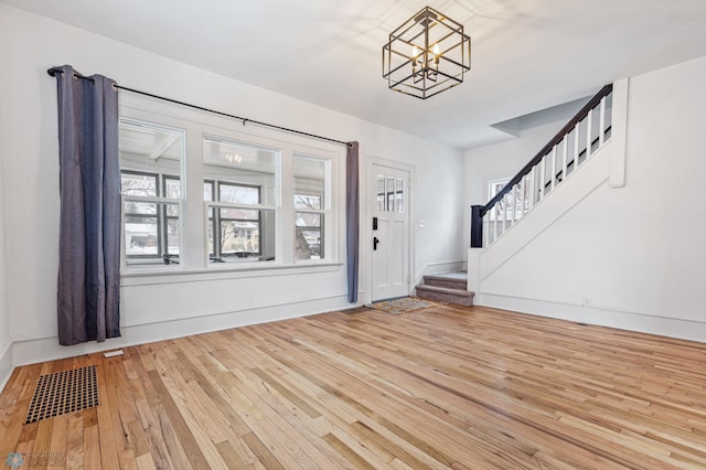 entryway featuring plenty of natural light, wood-type flooring, and a notable chandelier