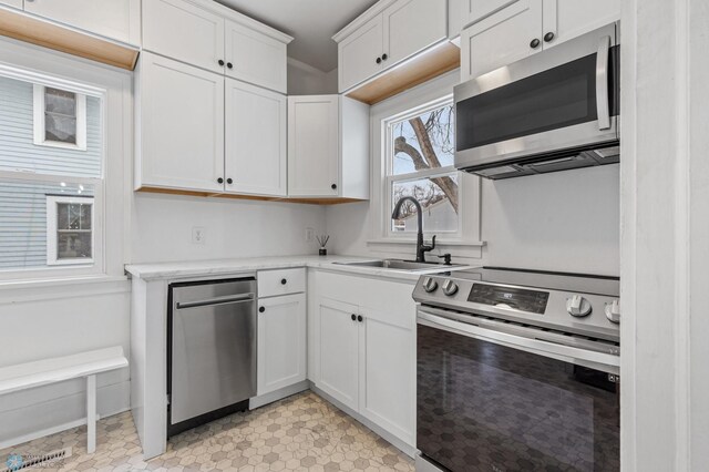 kitchen featuring appliances with stainless steel finishes, sink, and white cabinets