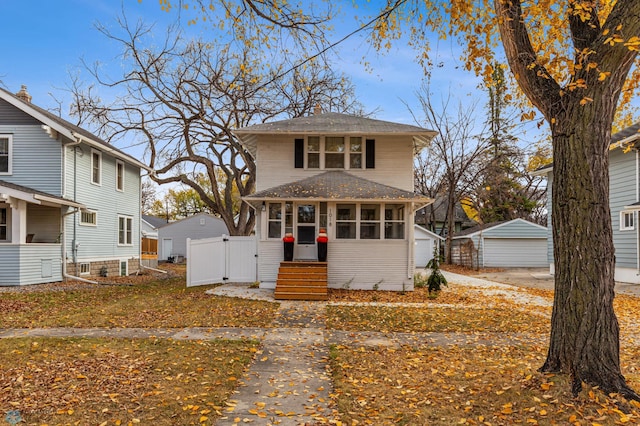 1018 11th St S, Fargo, ND 58103 - traditional style home featuring a detached garage, a sunroom, an outbuilding, and a gate