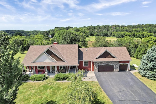 view of front of property with a garage, covered porch, and a front lawn