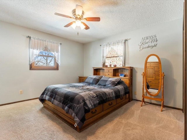 bedroom with baseboards, a textured ceiling, and light colored carpet