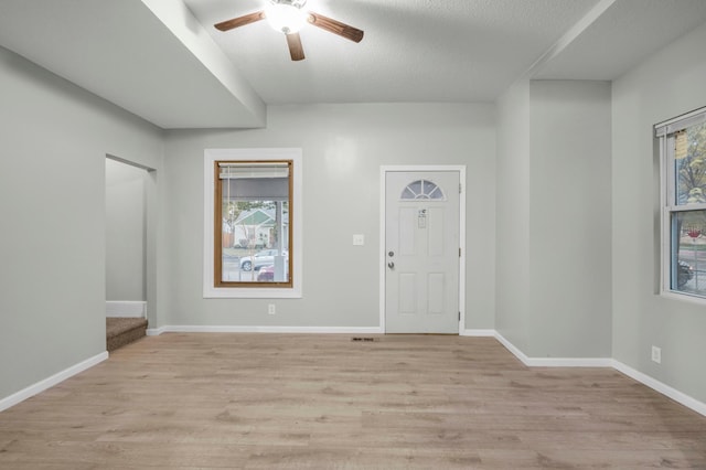 entryway with a textured ceiling, light hardwood / wood-style floors, plenty of natural light, and ceiling fan