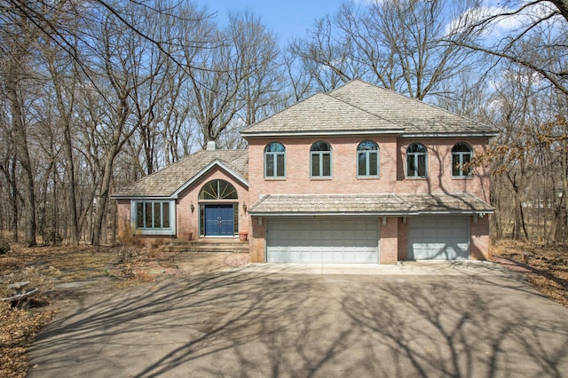 view of front of property featuring aphalt driveway, brick siding, and a garage