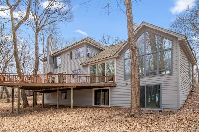 rear view of house with a chimney and a deck