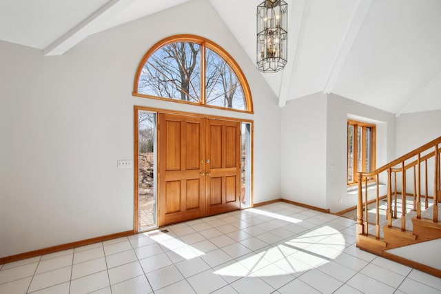 entryway featuring an inviting chandelier, stairs, light tile patterned flooring, baseboards, and high vaulted ceiling