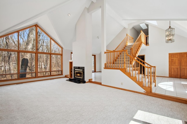 unfurnished living room with carpet floors, baseboards, stairs, and high vaulted ceiling