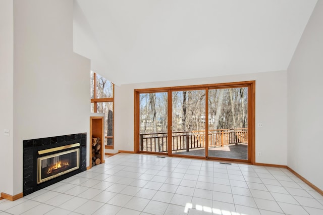 unfurnished living room with a fireplace, lofted ceiling, visible vents, and baseboards