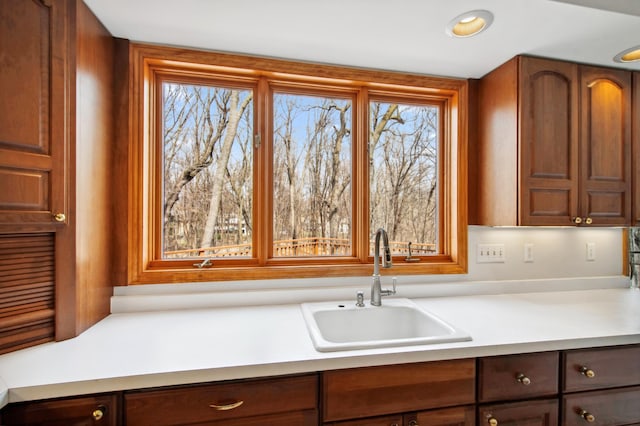 kitchen featuring light countertops, a sink, and a healthy amount of sunlight