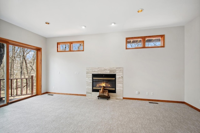 unfurnished living room featuring a fireplace, carpet, visible vents, and baseboards