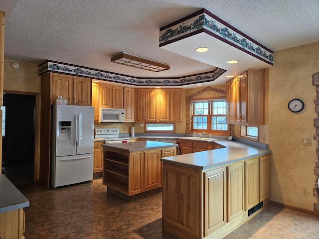 kitchen with a textured ceiling, a center island, white appliances, and sink